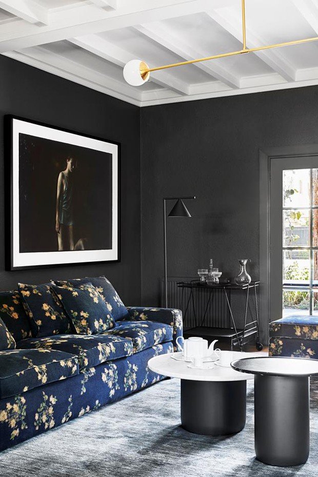 DECÓR DO DIA - sala de estar com paredes pretas e sofá florido.